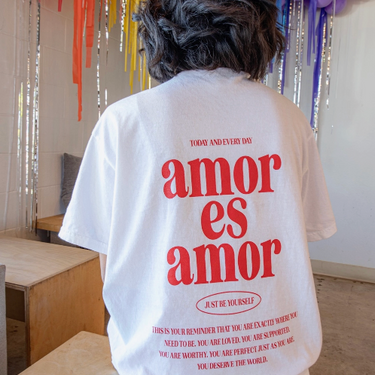 A white typographic t-shirt with 'amor es amor' text